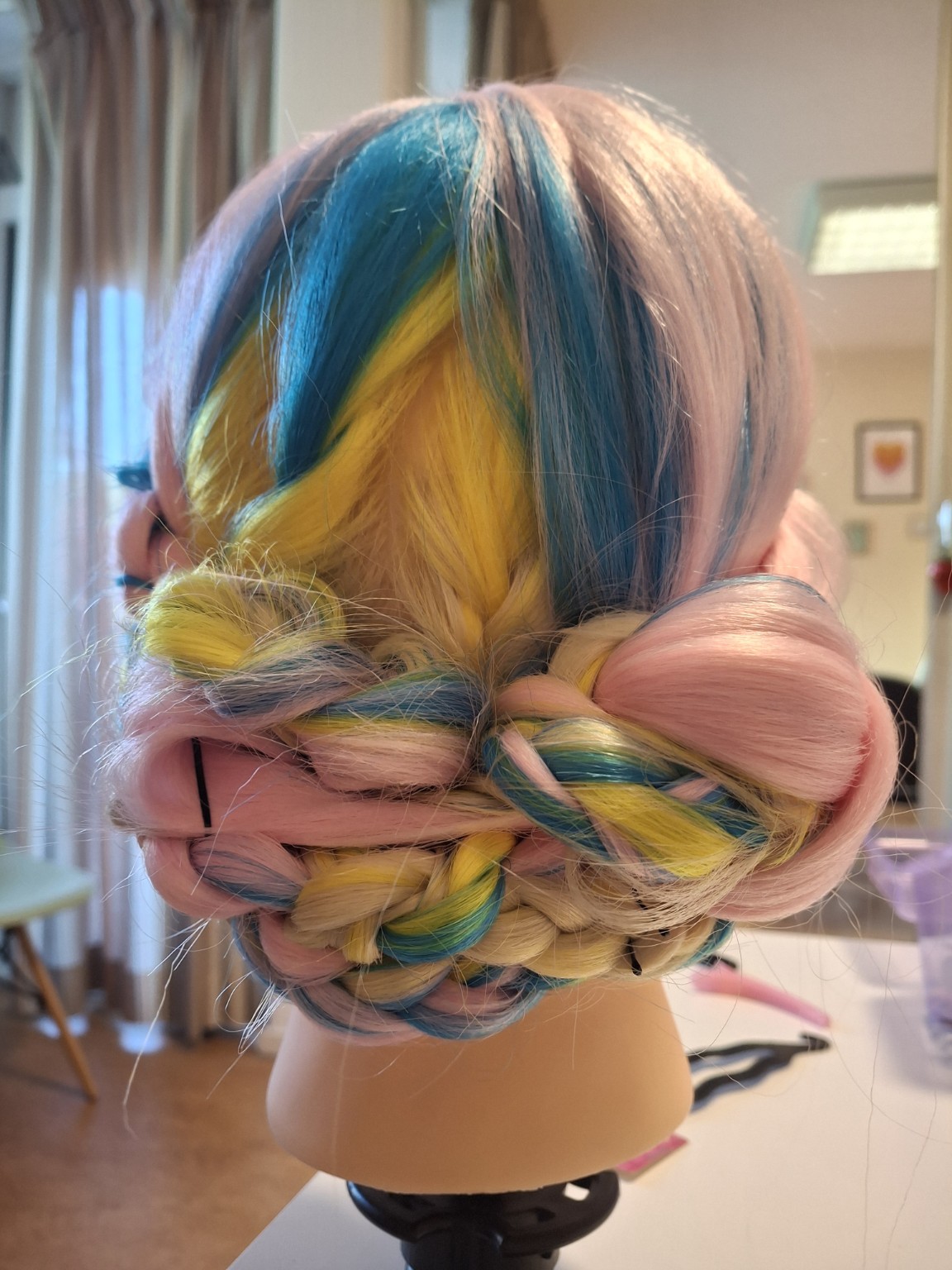 Kleurrijke haarstyling op een oefenhoofd